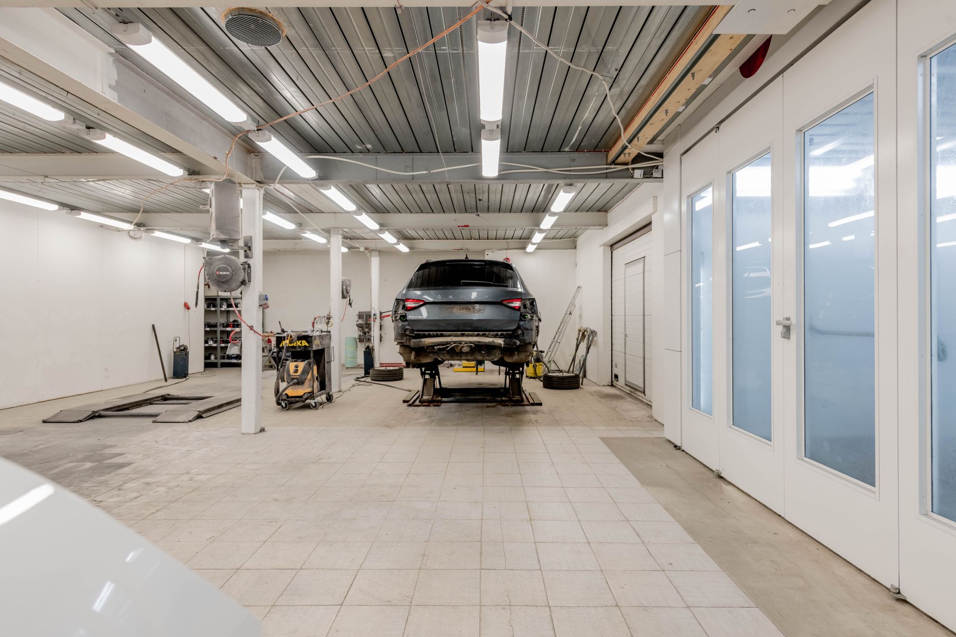 Werkstatt mit Auto auf der Hebebühne